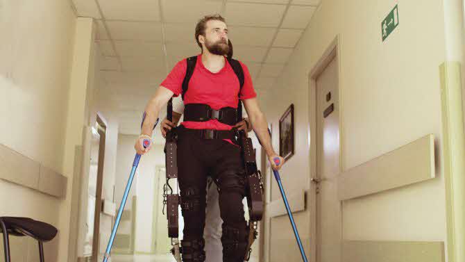 Man walking with the help of a robotic exoskeleton